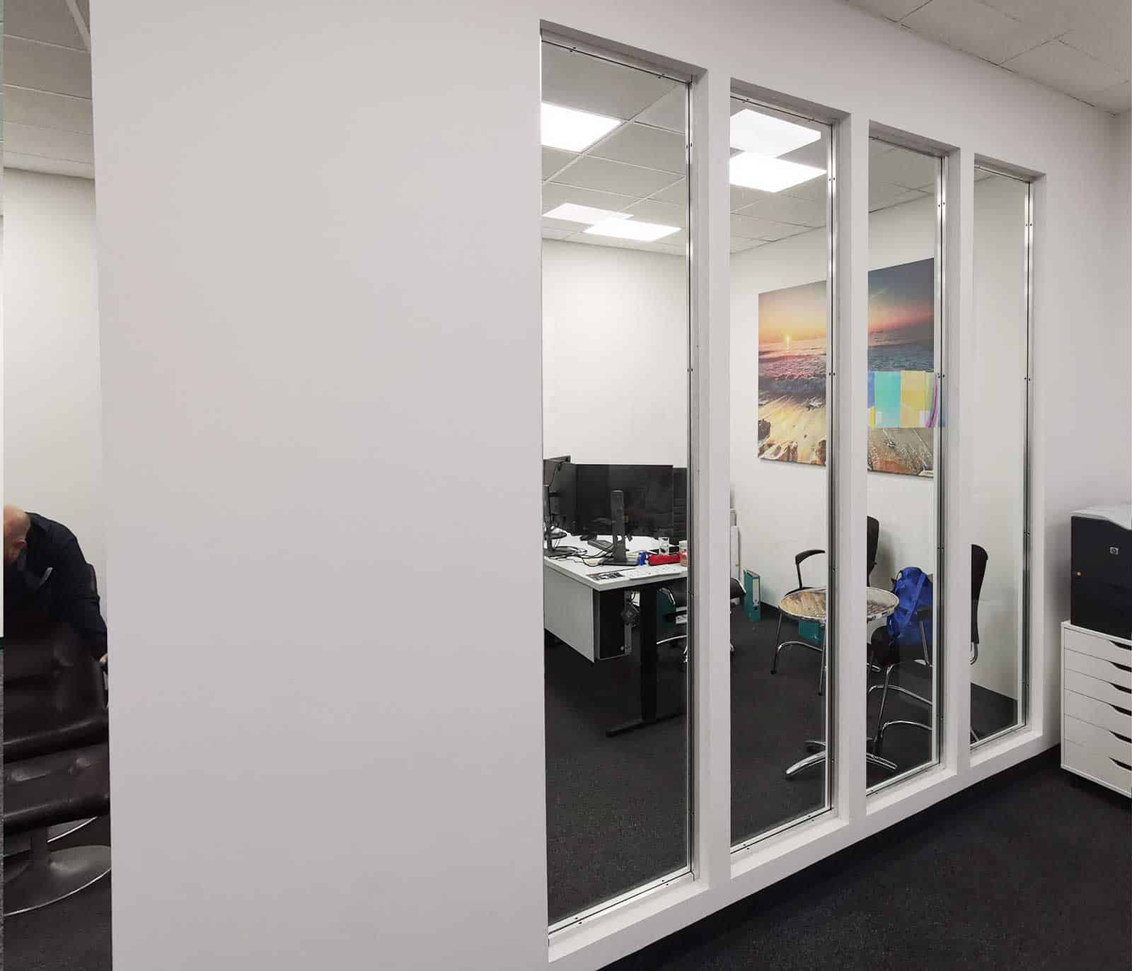 Vier hohe Glaselemente als Abtrennung zu Büroraum - vor der Beklebung.